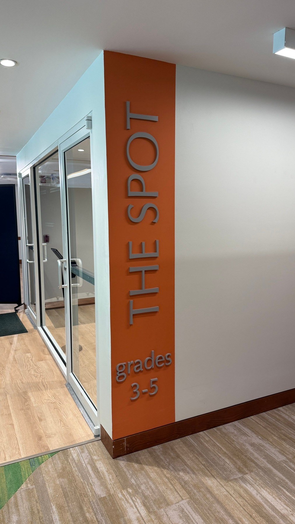 Vertical dimensional lettering on an orange interior wall